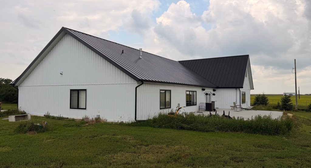 Explore the custom Homestead with loft built for Tyler near Kindersley, SK. Features upgraded Board and Batten Bright White siding and a functional, high-capacity design.