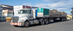 Integrity Building Products delivery trucks loaded with construction framing materials for home builders.