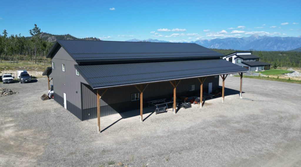 A charcoal post-frame agriculture storage building with wainscoting and overhead doors