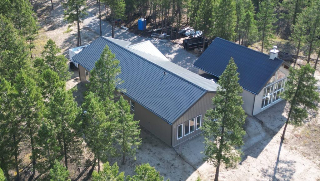 A custom residential post-frame home with soffits, and overhead doors