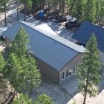 A custom residential post-frame home with soffits, and overhead doors