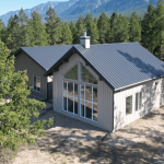 A custom residential post-frame home with soffits, and overhead doors