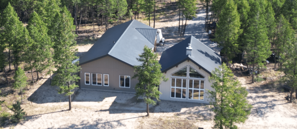 A custom residential post-frame home with soffits, and overhead doors