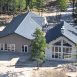 A custom residential post-frame home with soffits, and overhead doors