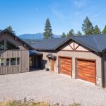 A custom residential post-frame home with soffits, and overhead doors