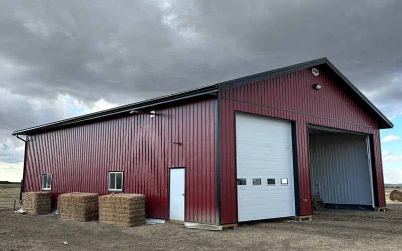 A dark red post-frame agriculture storage building