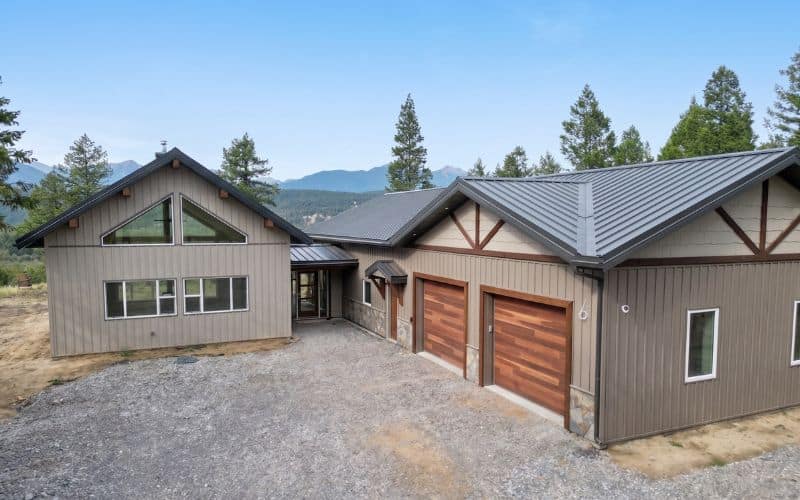 A custom residential post-frame home with soffits, and overhead doors