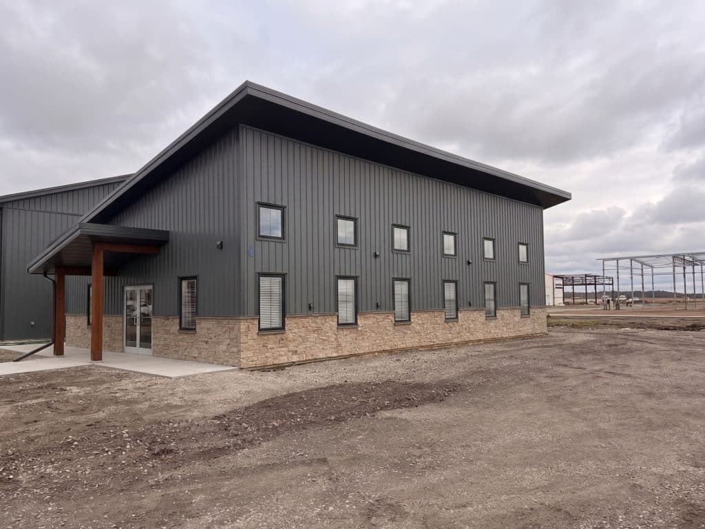 A charcoal post-frame commercial office building with wainscoting and a covered front entry way