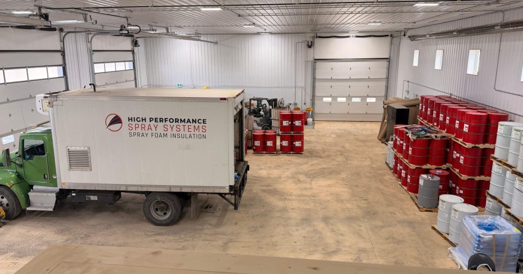 A charcoal post-frame commercial storage building with wainscoting and overhead doors