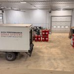 A charcoal post-frame commercial storage building with wainscoting and overhead doors