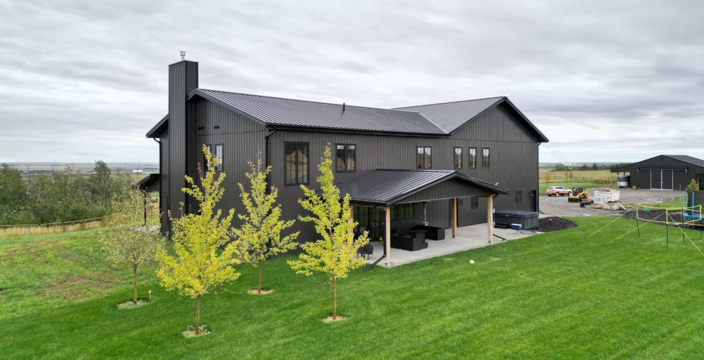 A post-frame custom home with a front porch, timber accents, and an attached garage