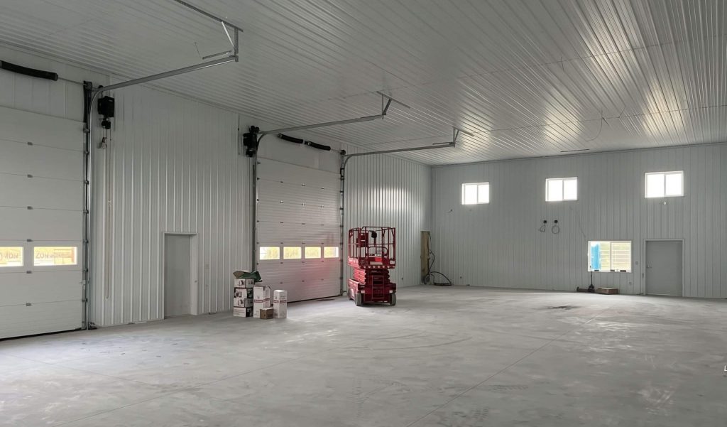 A white white post-frame agriculture storage building with wainscoting