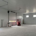 A white white post-frame agriculture storage building with wainscoting