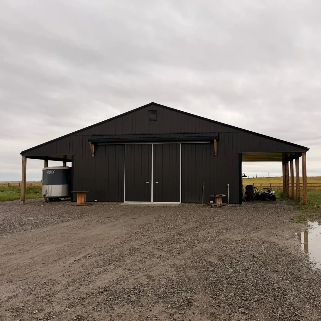A post-frame storage barn with two open lean-tos and a sliding door