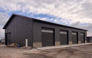 A charcoal post-frame commercial storage building with wainscoting and overhead doors