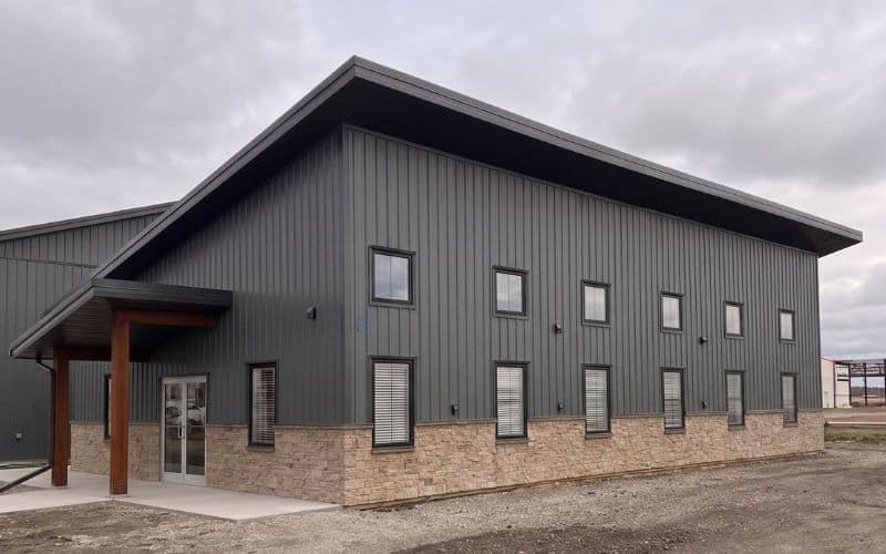 A charcoal post-frame commercial office building with wainscoting and a covered front entry way
