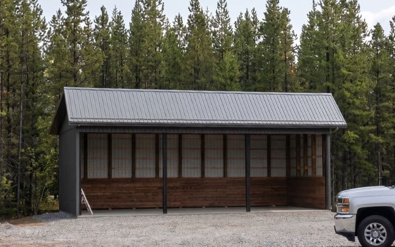 A post-frame open livestock shelter with soffits and interior kick-wall