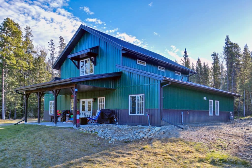 Integrity Barndominium with green metal cladding and black wainscoting