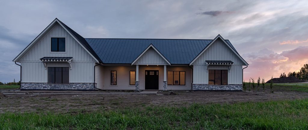 A white white post-frame residential Homestead with wainscoting and a overhead door