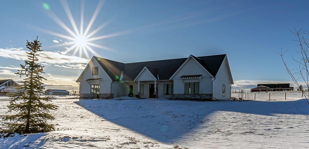 A white white post-frame residential Homestead with wainscoiting and a overhead door