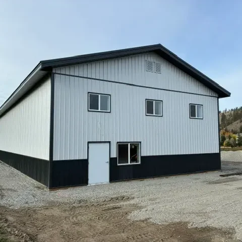 A white white post-frame agriculture storage building with wainscoting