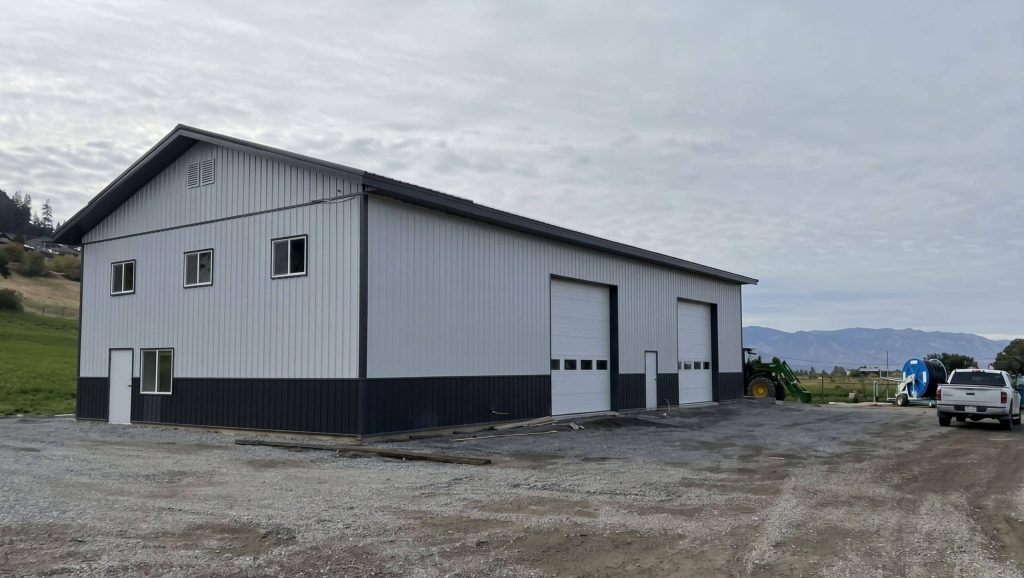 A white white post-frame agriculture storage building with wainscoting