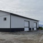 A white white post-frame agriculture storage building with wainscoting