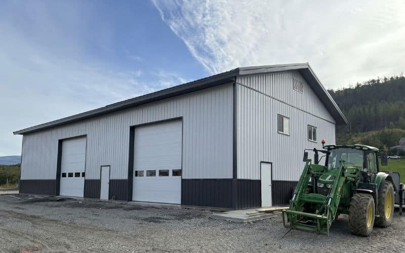 A white white post-frame agriculture storage building with wainscoting