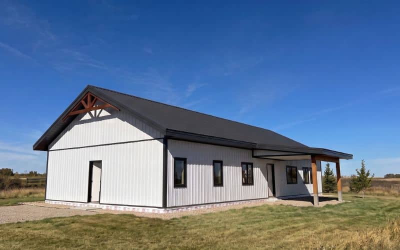 A bright white post-frame Residential Bunkhouse with timber accents